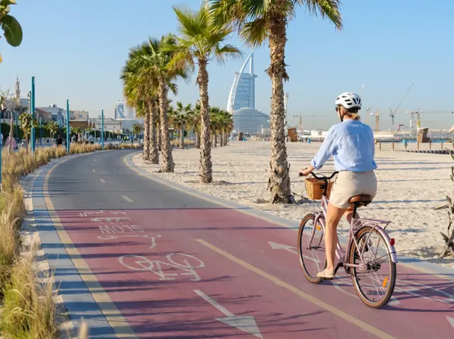 Riding a Mogoo city bike on the Jumeirah beach cycle track, Burj Al Arab behind