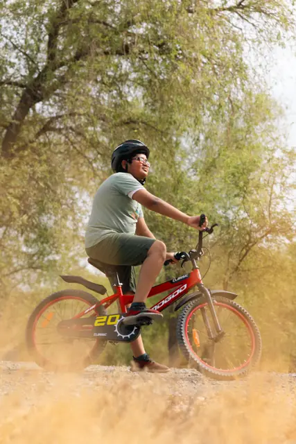 Boy kicking up dust on a red Mogoo bike