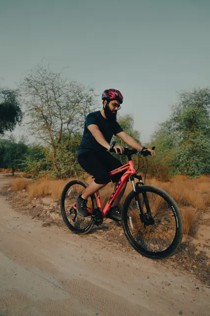 Rider climbing a desert trail on a Mogoo mountain bike